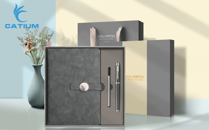 Mẫu set sổ bút quà tặng doanh nghiệp tinh tế với thiết kế sổ bìa da cổ điển và bút ký hiện đại, đi kèm hộp và túi giấy đồng bộ